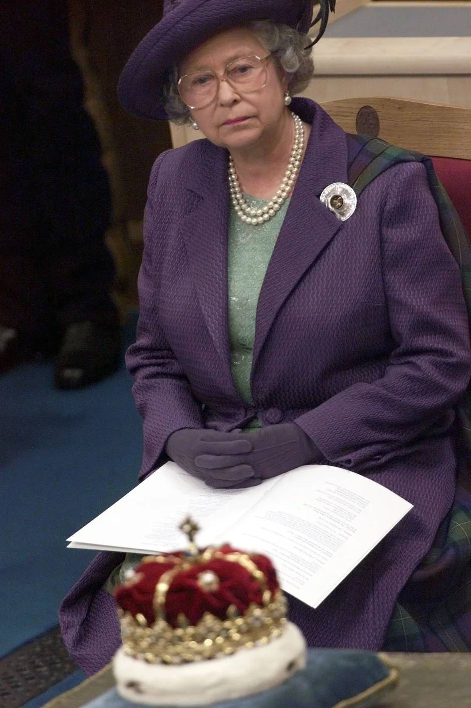 Королева Великобритании Елизавета II осматривает шотландскую корону после открытия шотландского парламента в зале парламента в Эдинбурге.