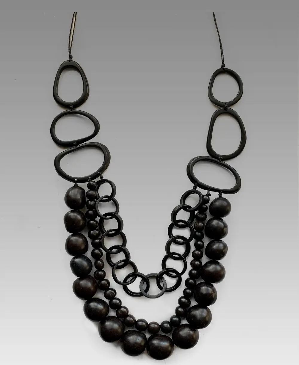 Ожерелье Nuit Noire, изготовленное из орехов тагуа в форме петель и кругов, семян асаи, орехов бомбона и органического хлопкового шнура.
